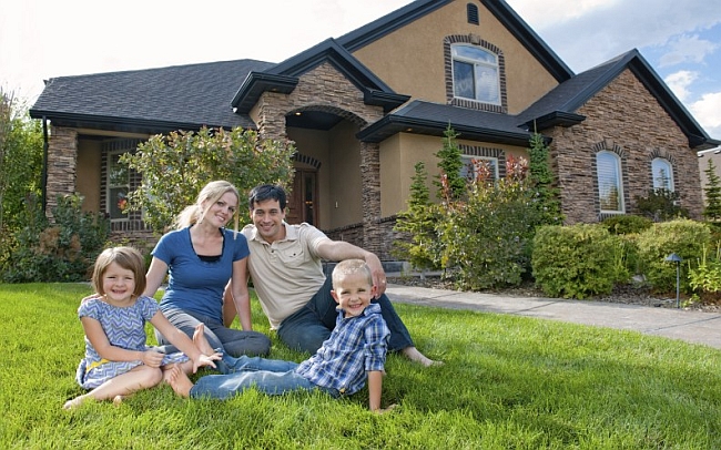 Family-of-Four-on-Lawn-with-Beautiful-Home-in-Background.jpg